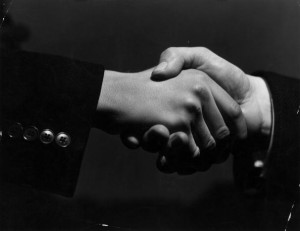 16th February 1938:  A close-up of two hands grasping each other in a firm handshake.  (Photo by Fox Photos/Getty Images)